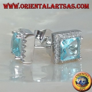 Pendientes de plata con topacio azul natural engastados en un cuadrado rodeado de circonitas.