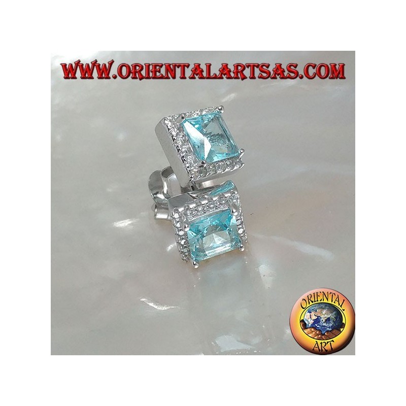 Pendientes de plata con topacio azul natural engastados en un cuadrado rodeado de circonitas.