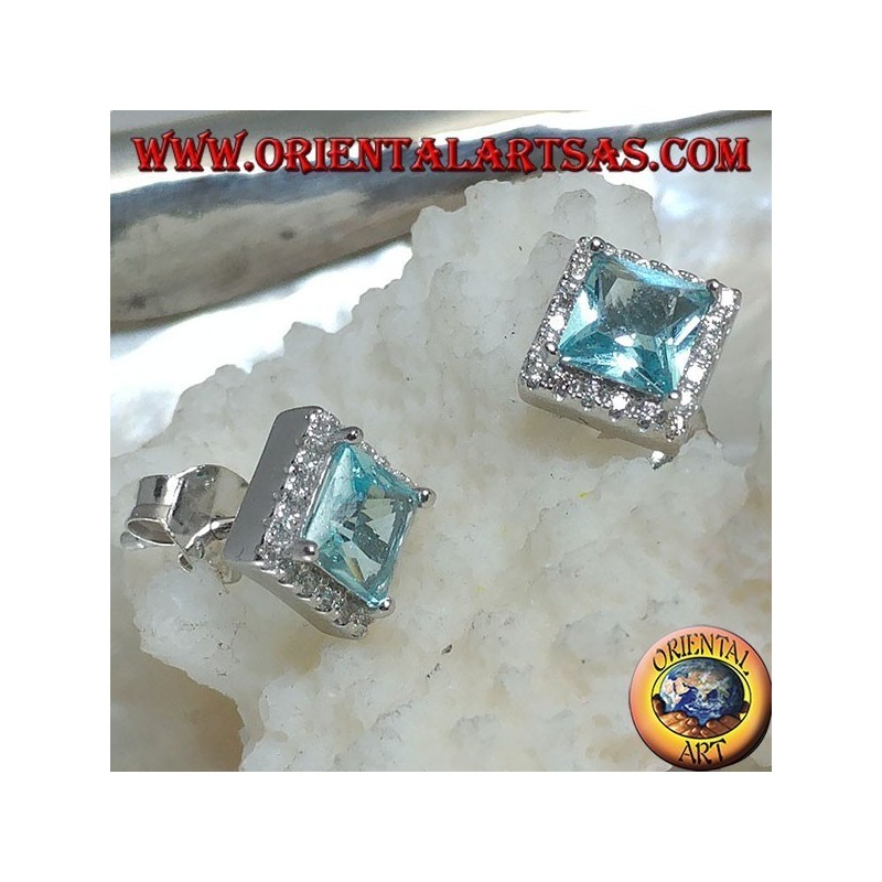 Pendientes de plata con topacio azul natural engastados en un cuadrado rodeado de circonitas.