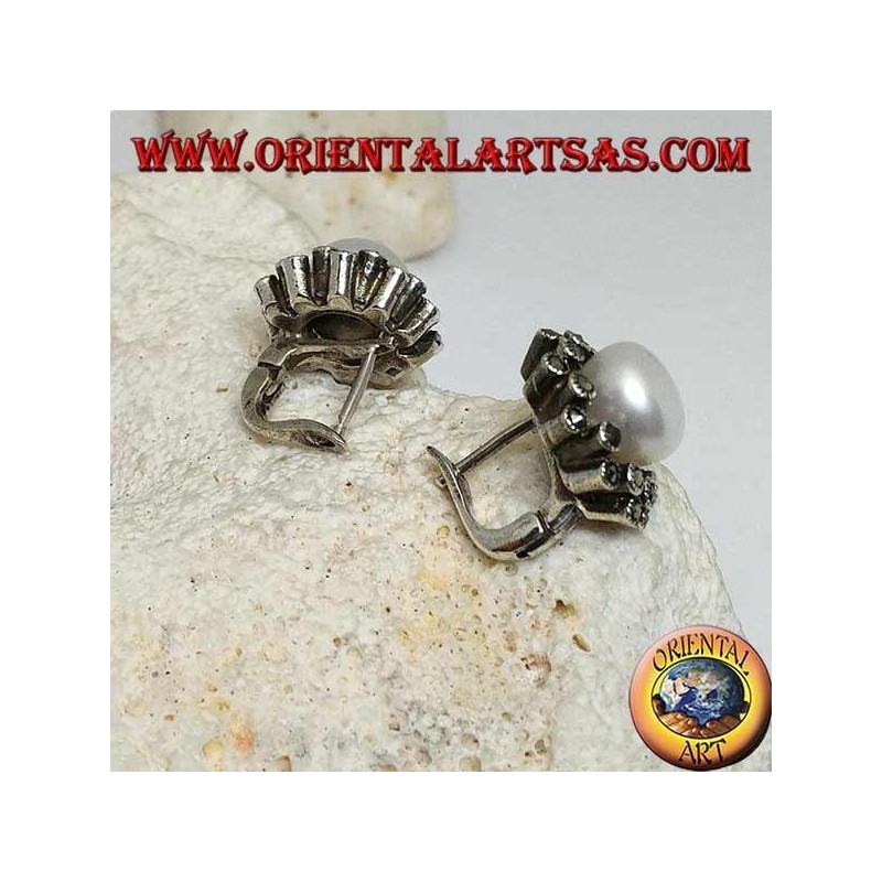 Orecchini in argento a chiusura a leva con perla d'acqua dolce contornata da due linee alternate di marcassite