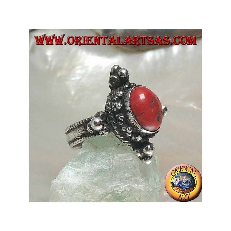 Silver ring with oval Tibetan antique coral surrounded by dots on a Nepalese setting