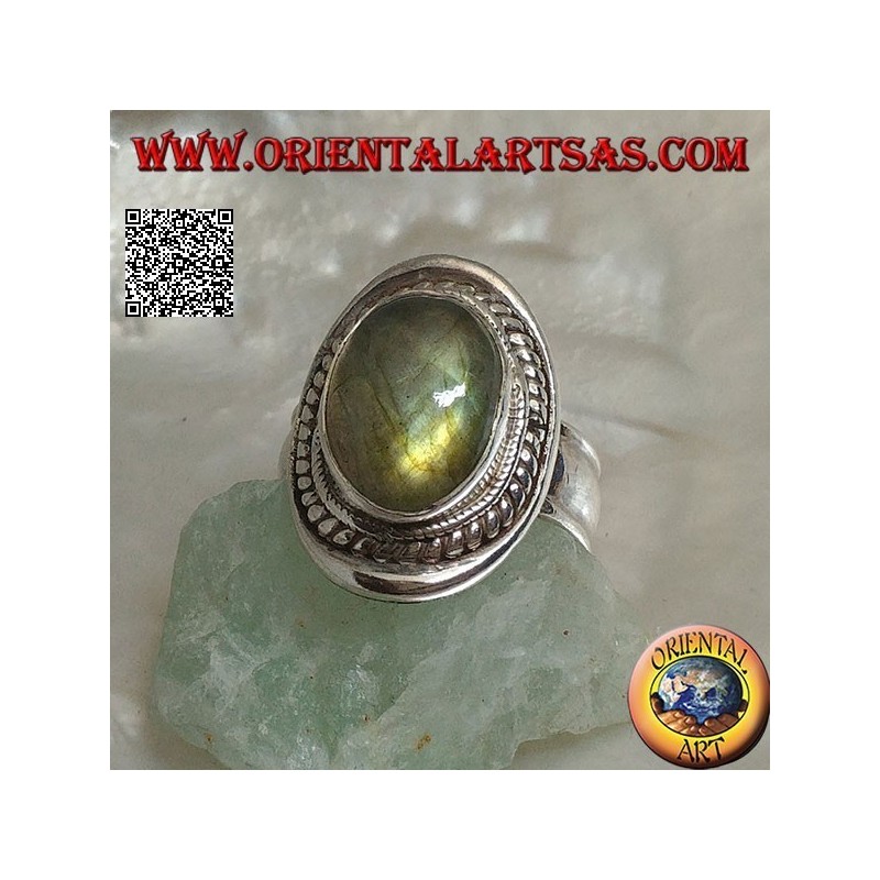 Silver ring with oval cabochon labradorite surrounded by intertwining on a smooth shield
