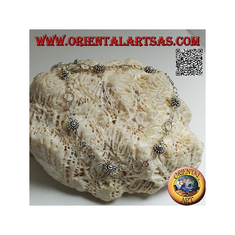 Pulsera de plata suave con flores y círculos alternos y campana final.