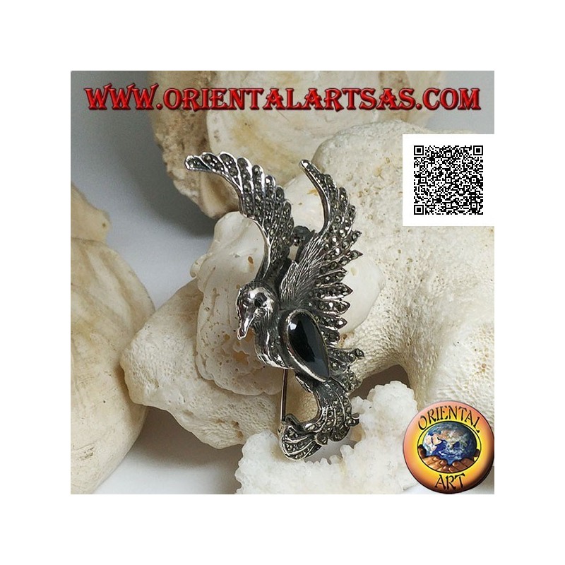 Silver brooch in the shape of a phoenix in flight in profile studded with marcasite and with a drop of onyx