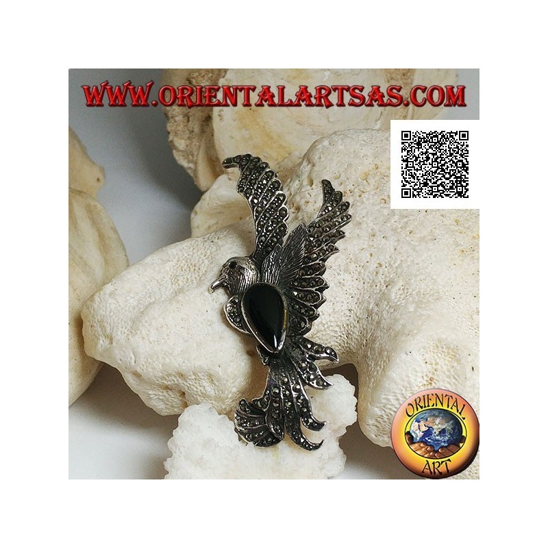 Broche de plata con forma de fénix en vuelo de perfil tachonado de marcasita y con una gota de ónix