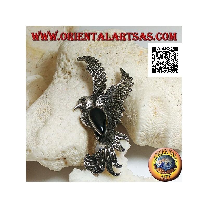Silver brooch in the shape of a phoenix in flight in profile studded with marcasite and with a drop of onyx