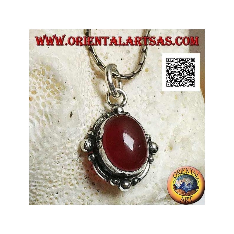 Pendentif en argent avec une cornaline cabochon ovale entouré d'argent avec une boule sur les quatre points cardinaux