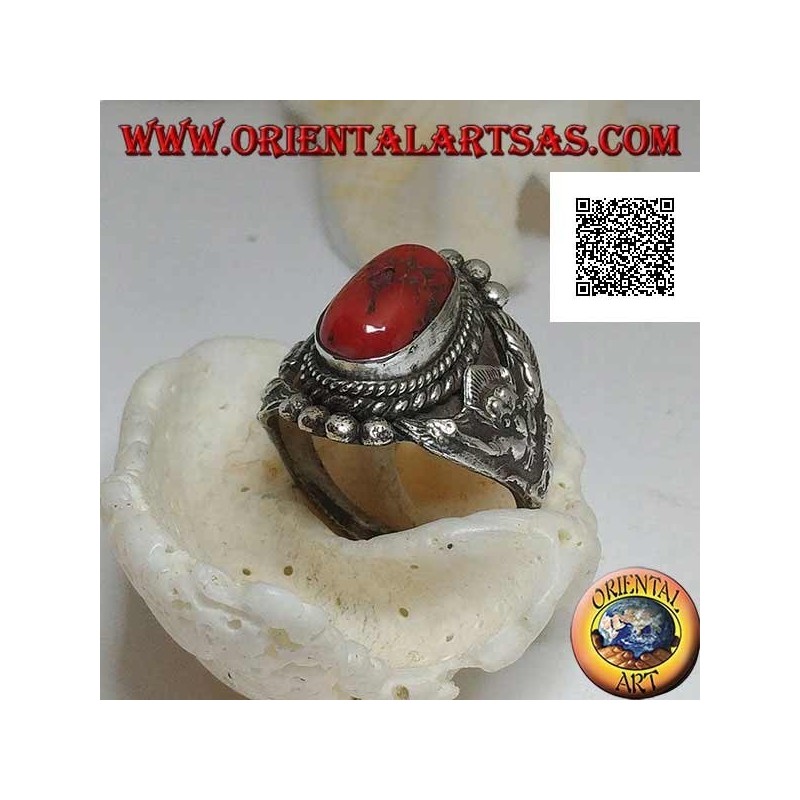 Anillo de plata con coral tibetano antiguo en un entorno nepalí con Garuḍa (dios progenitor de las aves) a los lados