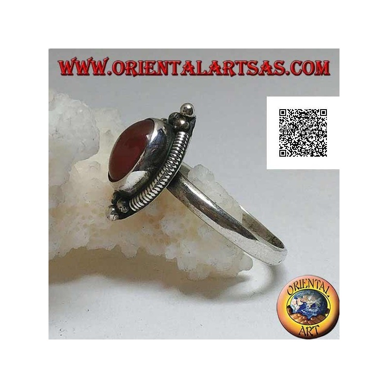 Silver ring with oval cabochon carnelian surrounded by stripes and trio of balls above and below