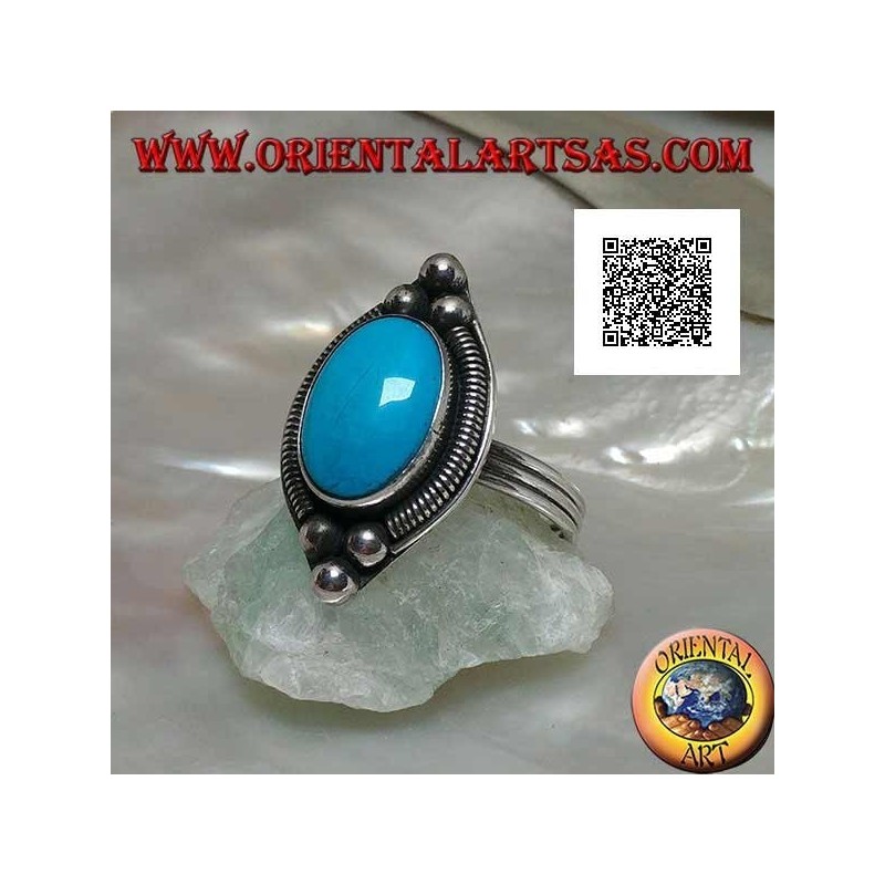 Silver ring with cabochon oval turquoise surrounded by interweaving on a plate and three balls above and below