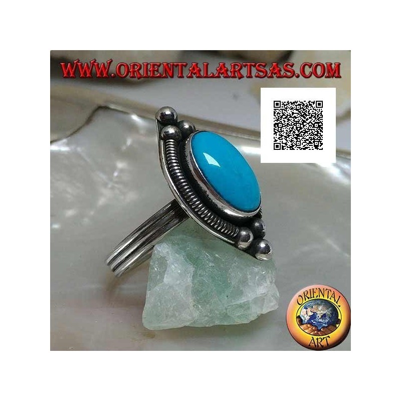 Silver ring with cabochon oval turquoise surrounded by interweaving on a plate and three balls above and below