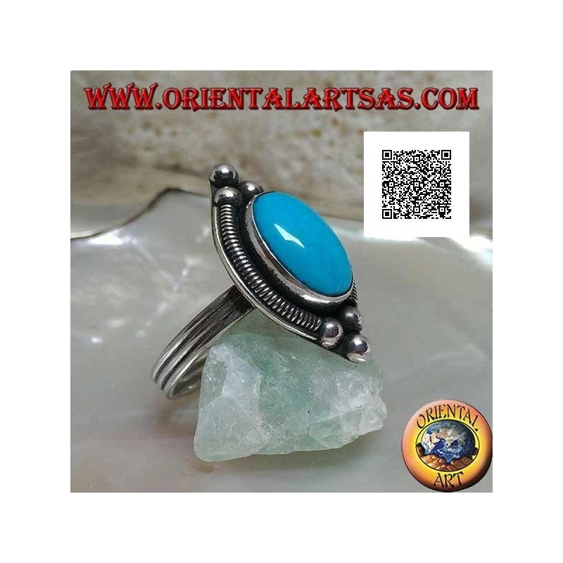Silver ring with cabochon oval turquoise surrounded by interweaving on a plate and three balls above and below