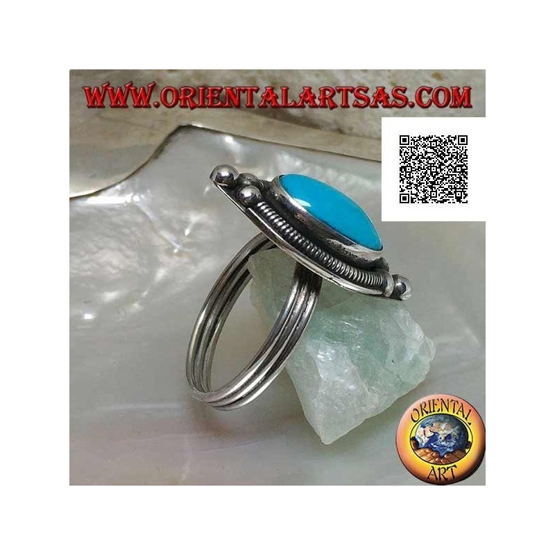 Anillo de plata con cabujón ovalado turquesa rodeado de entretejido en un plato y tres bolas arriba y abajo