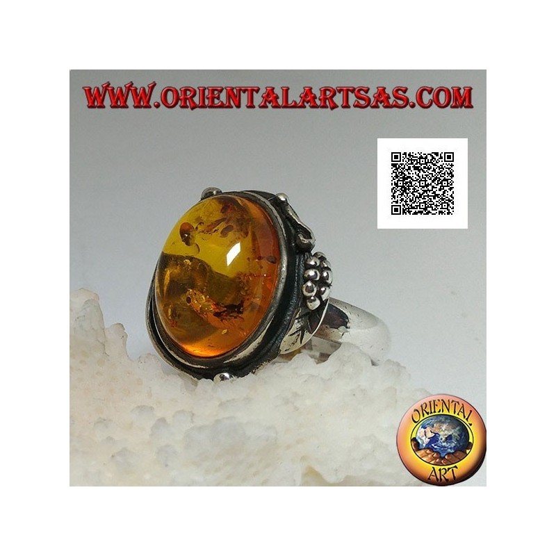 Silver ring with cabochon oval amber with two balls and a leaf on the edge