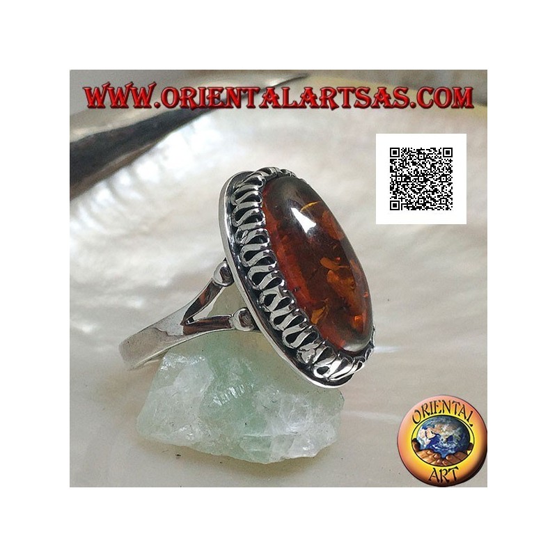 Silver ring with elongated oval amber surrounded by a serpentine in relief