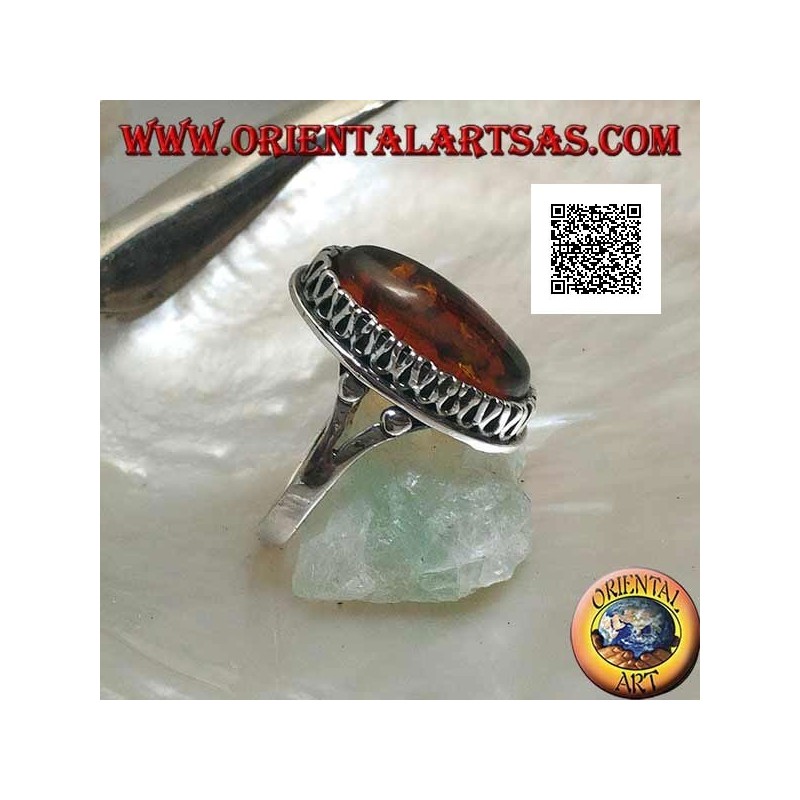 Silver ring with elongated oval amber surrounded by a serpentine in relief