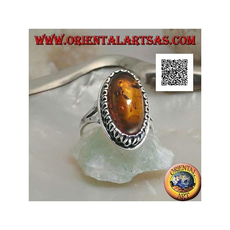 Silver ring with elongated oval amber surrounded by a serpentine in relief