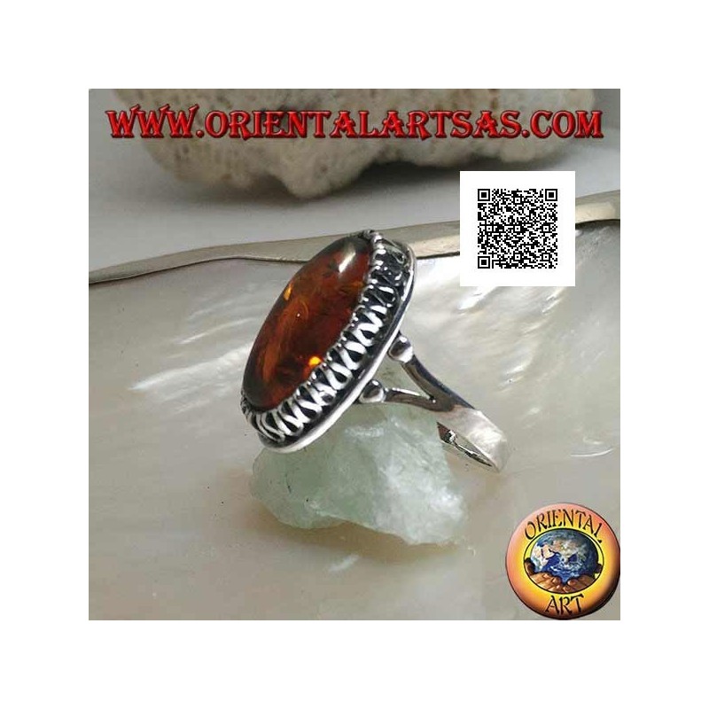 Silver ring with elongated oval amber surrounded by a serpentine in relief