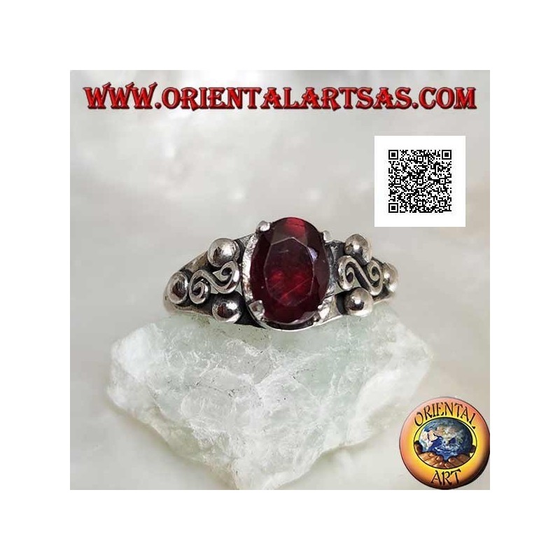 Silver ring with oval garnet set and spiral S between three balls on the sides