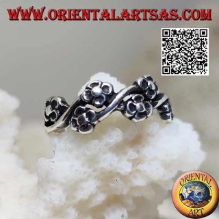Silver ring with pairs of small flowers on a wavy line