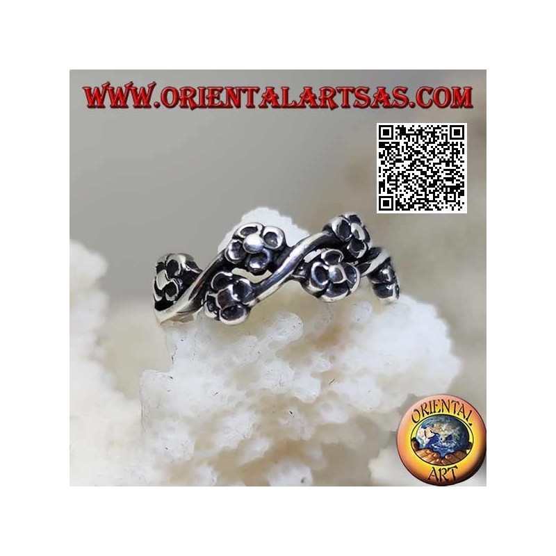 Silberring mit Paaren kleiner Blumen auf einer Wellenlinie