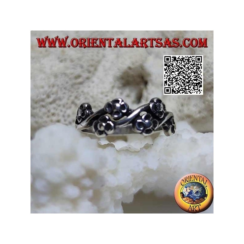 Silver ring with pairs of small flowers on a wavy line