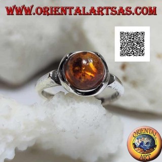 Bague en argent avec cabochon rond d'ambre entouré de demi-cercles sur une monture lisse