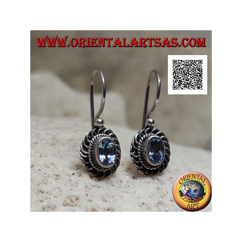 Silver earrings with faceted oval blue topaz surrounded by interweaving and bas-relief quotation marks