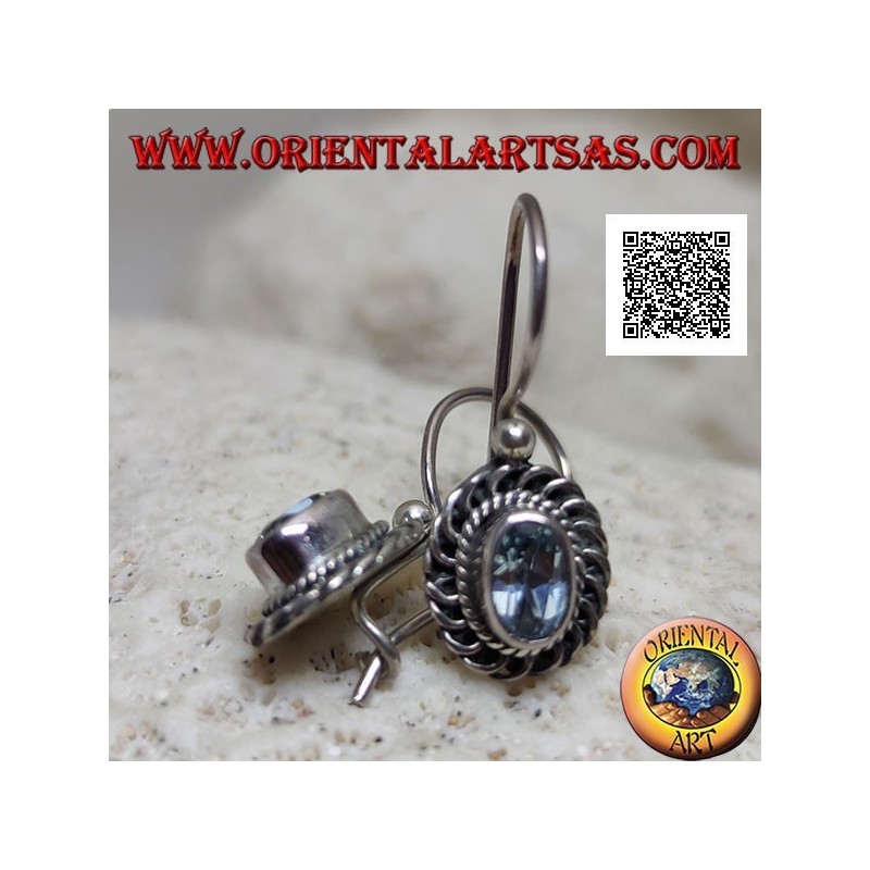 Silver earrings with faceted oval blue topaz surrounded by interweaving and bas-relief quotation marks