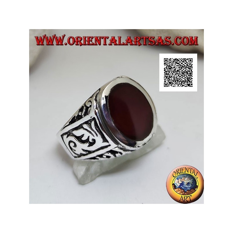 Silver ring with oval carnelian flush with the edge with gothic decorations in bas-relief on the sides