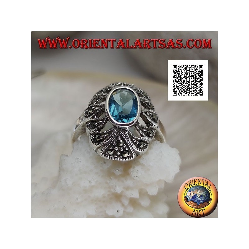 Bague en argent avec topaze bleue ovale sur un ovale convexe perforé parsemé de marcassite