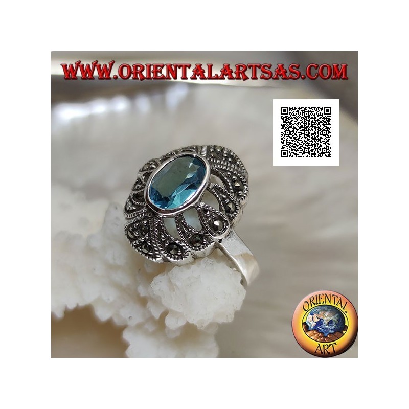Silver ring with oval blue topaz on an openwork convex oval studded with marcasite