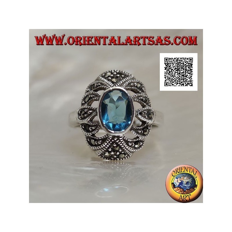 Bague en argent avec topaze bleue ovale sur un ovale convexe perforé parsemé de marcassite