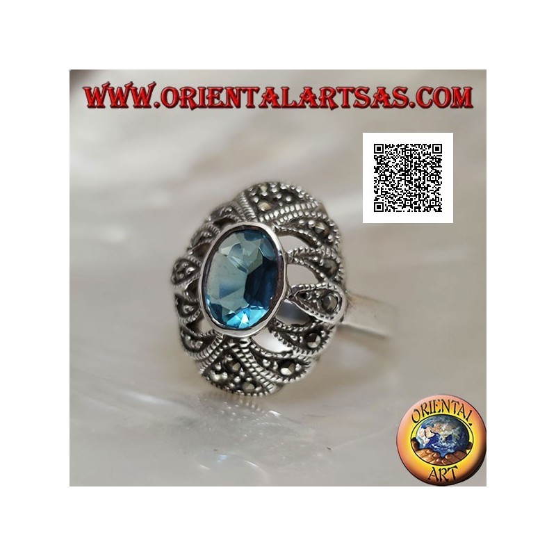 Anillo de plata con topacio azul ovalado sobre un óvalo convexo perforado tachonado de marcasita