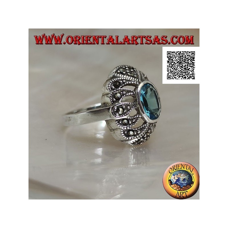 Silver ring with oval blue topaz on an openwork convex oval studded with marcasite