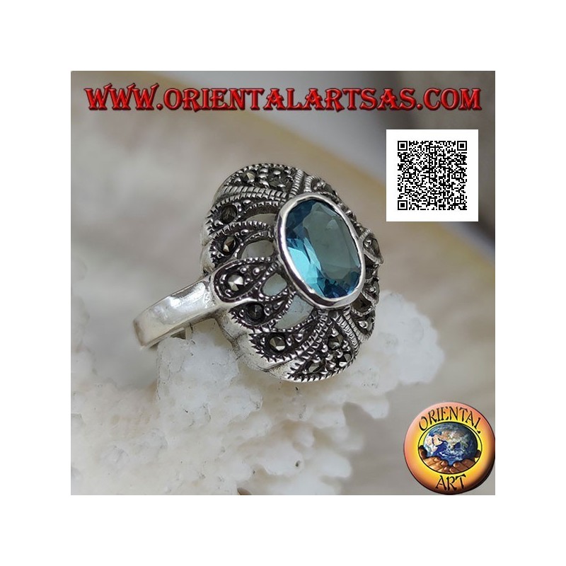 Anillo de plata con topacio azul ovalado sobre un óvalo convexo perforado tachonado de marcasita