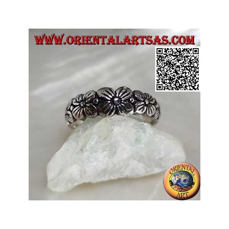 Anello in argento a fedina lavorata con fila crescente di fiori a quattro petali in rilievo