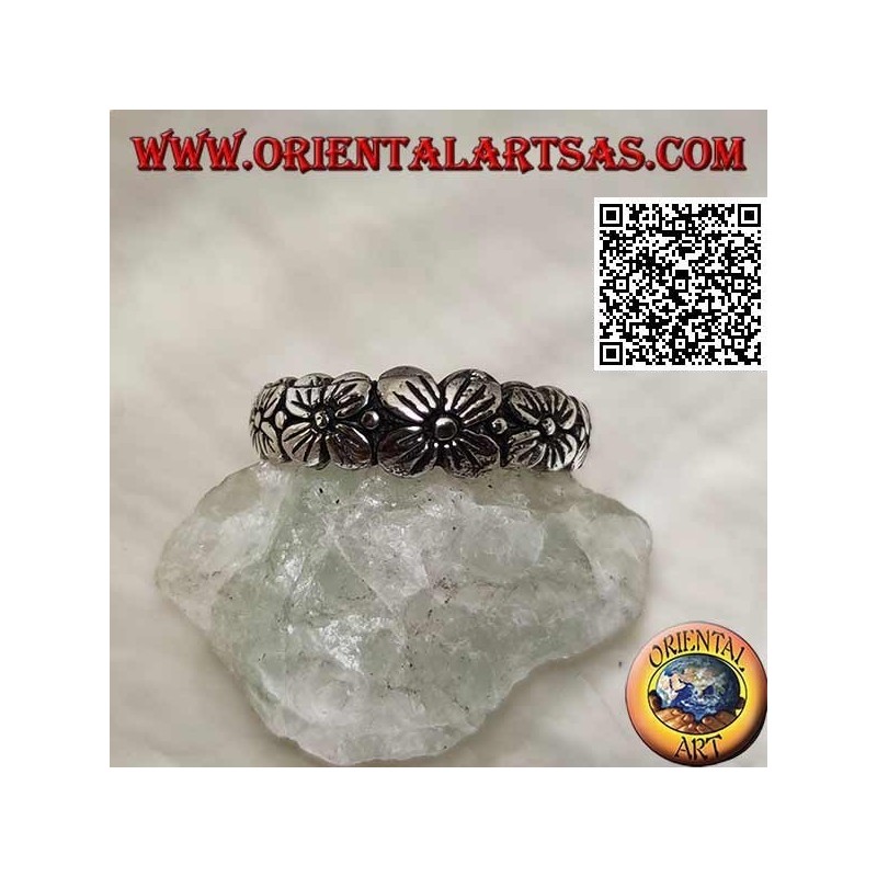 Silver ring with engraved band with growing row of four-petal flowers in relief