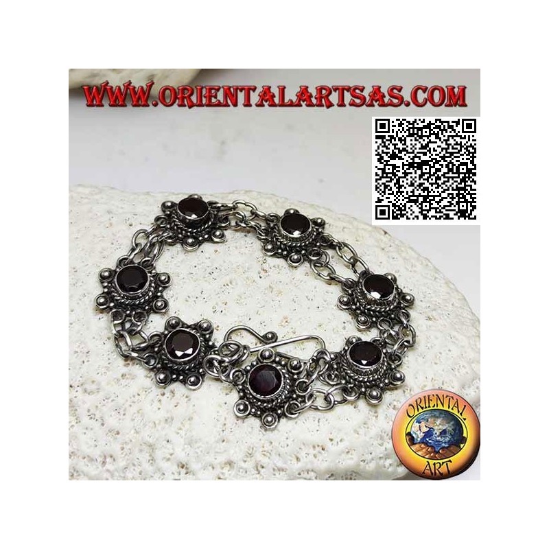 Silver bracelet of 7 flowers with central round faceted garnet joined by two chains