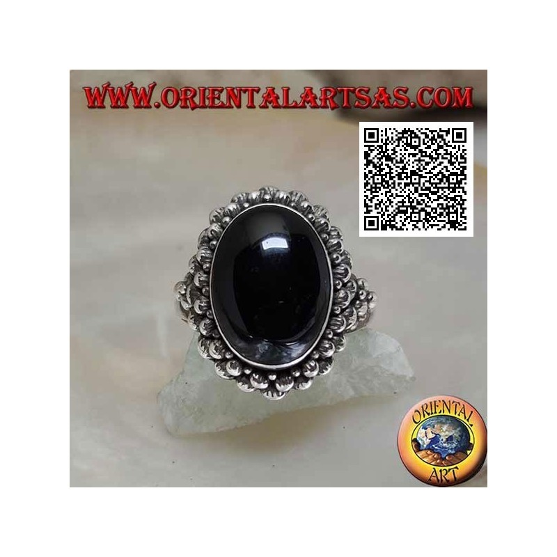 Silver ring with oval cabochon onyx surrounded by a double row of balls and balls on the sides