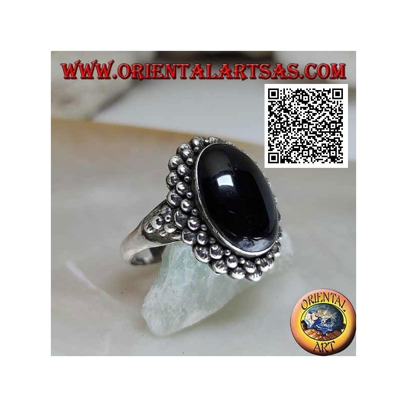 Silver ring with oval cabochon onyx surrounded by a double row of balls and balls on the sides
