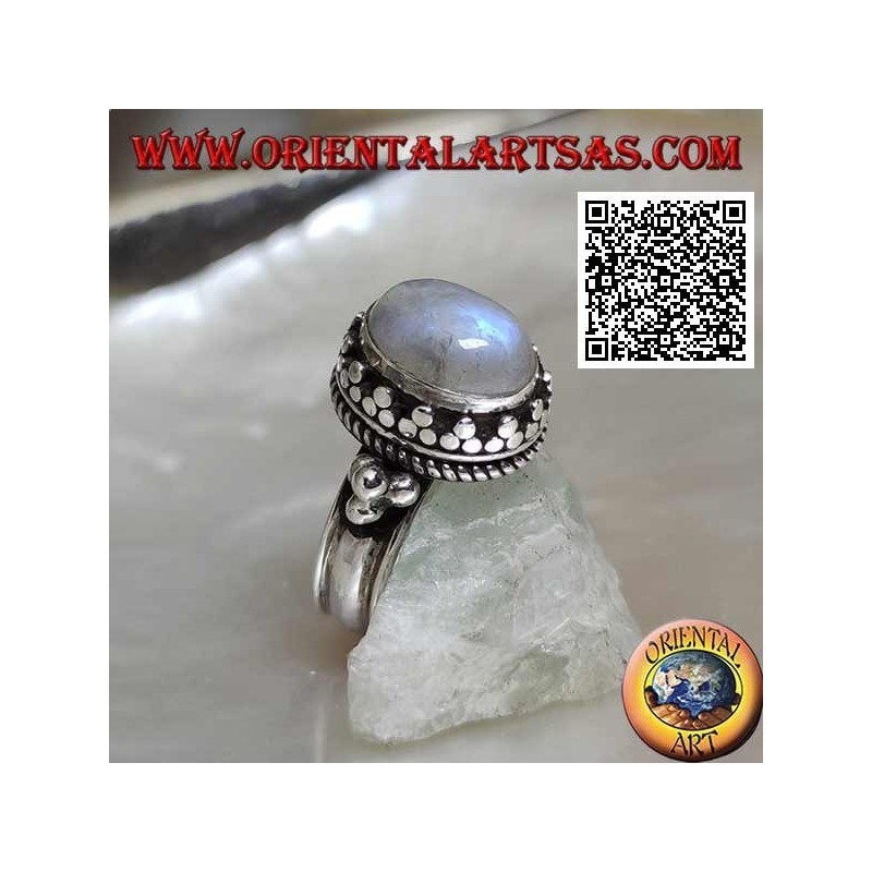 Silver ring with oval rainbow moonstone surrounded by trio of discs and intertwining