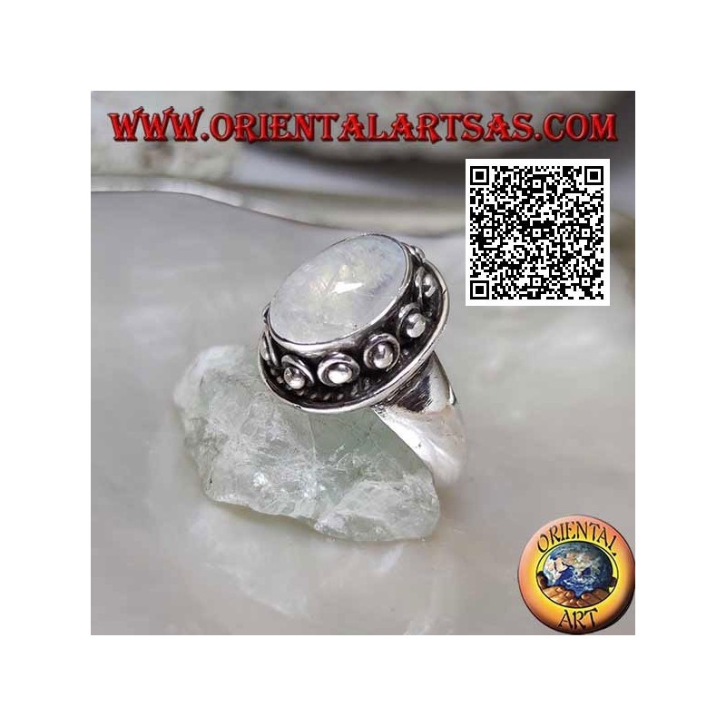 Silver ring with oval moonstone surrounded by interweaving and ball in the donut