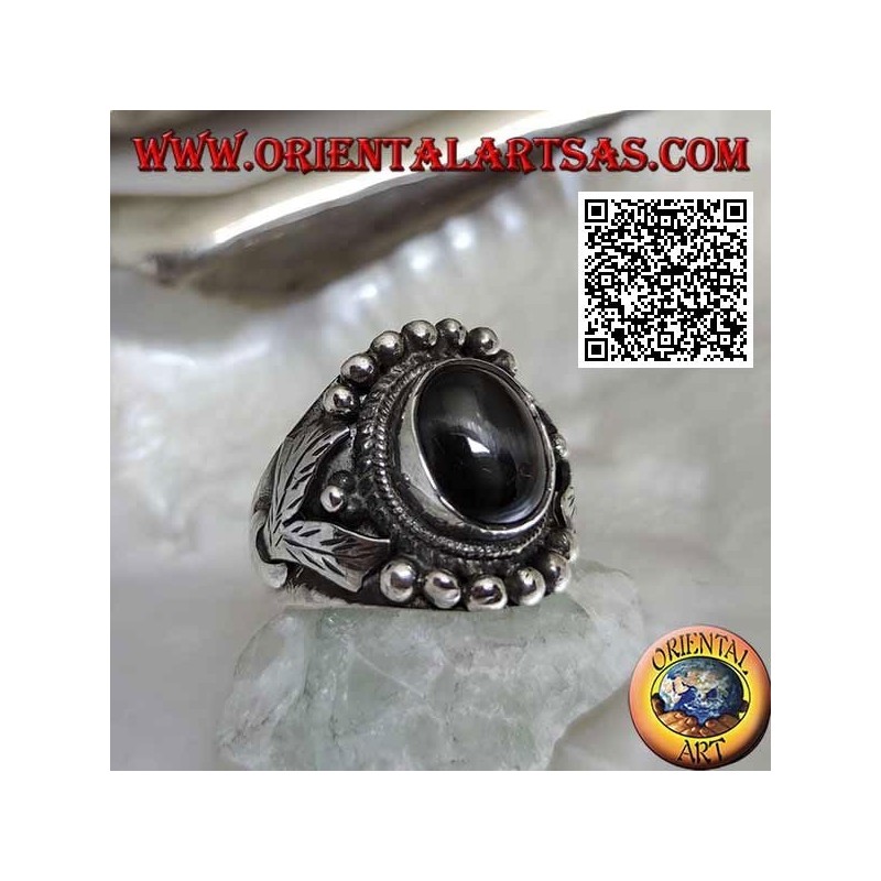 Silver ring with oval black star on ethnic setting with balls and leaves on the sides