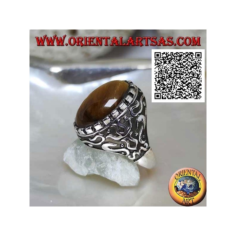 Anillo de plata con gran ojo de tigre ovalado de cabujón rodeado de decoraciones místicas en bajorrelieve