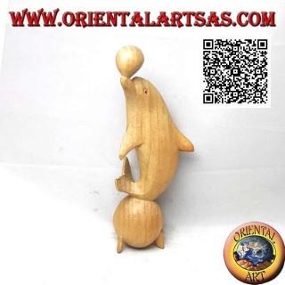 Escultura de un delfín haciendo malabares entre dos bolas de madera de hibisco de 20 cm