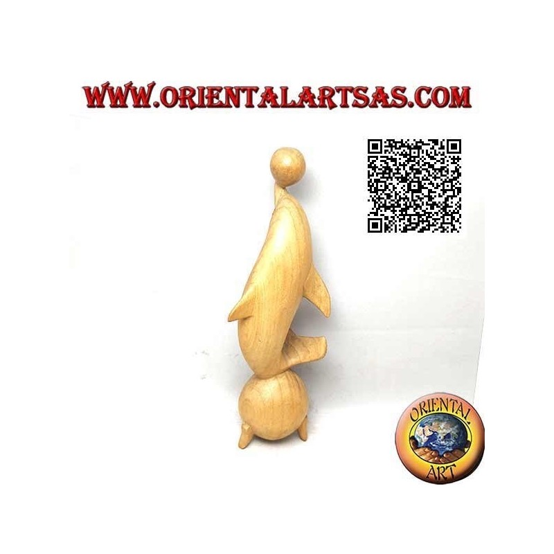 Sculpture of a dolphin juggling between two 20 cm hibiscus wood balls
