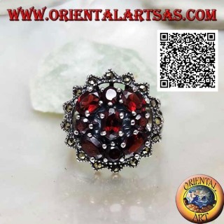 Bague en argent avec grenat ovale entouré de grenats ronds et ovales sous un soleil de marcassite