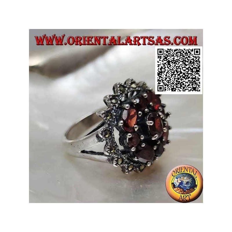 Anillo de plata con granate ovalado rodeado de granates redondos y ovalados en un sol de marcasita