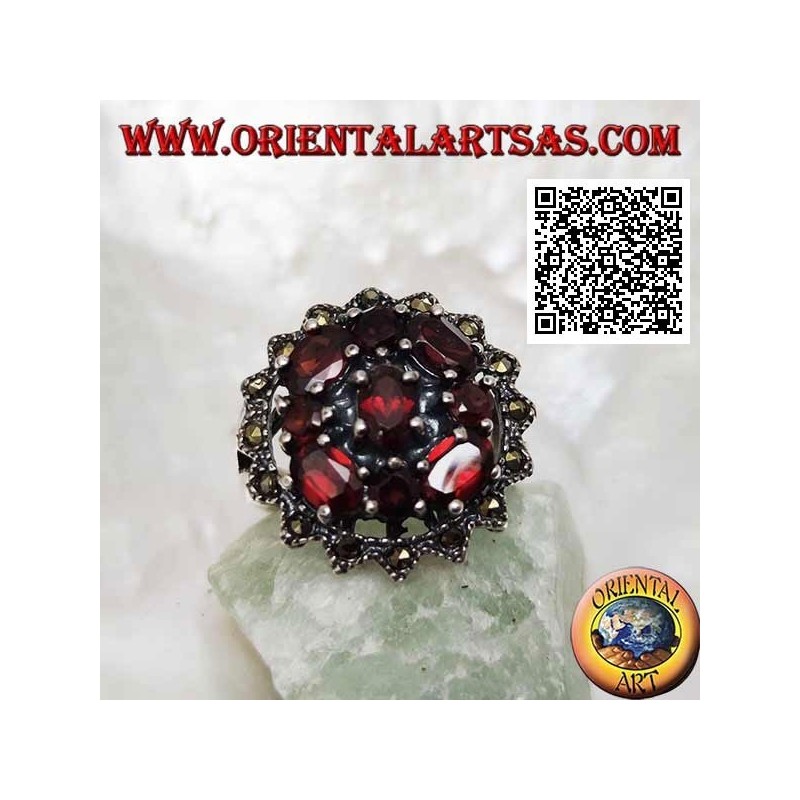 Bague en argent avec grenat ovale entouré de grenats ronds et ovales sous un soleil de marcassite